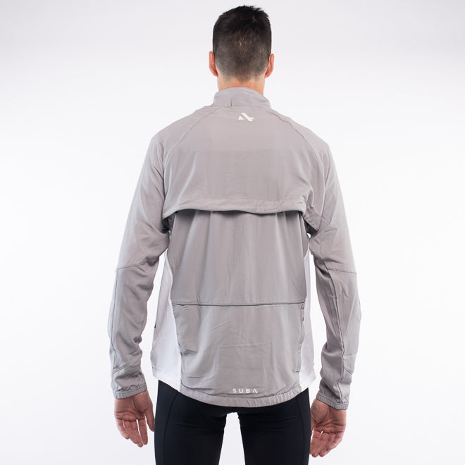 Person wearing a gray jacket with a brand logo on the back against a white background