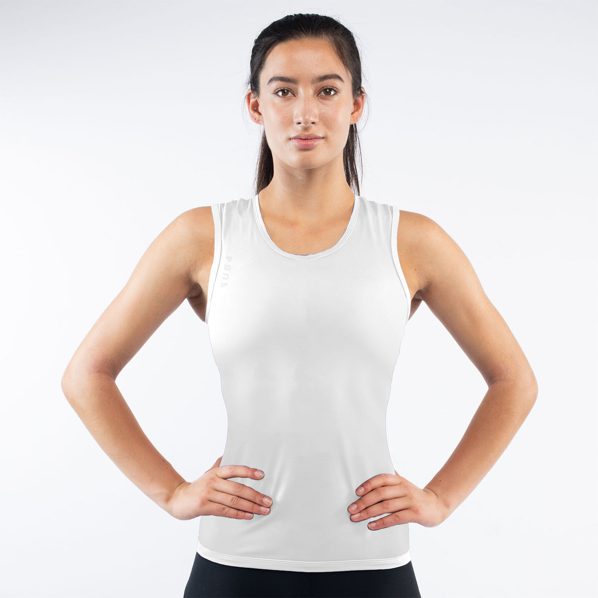 Woman wearing a white tank top against a plain background