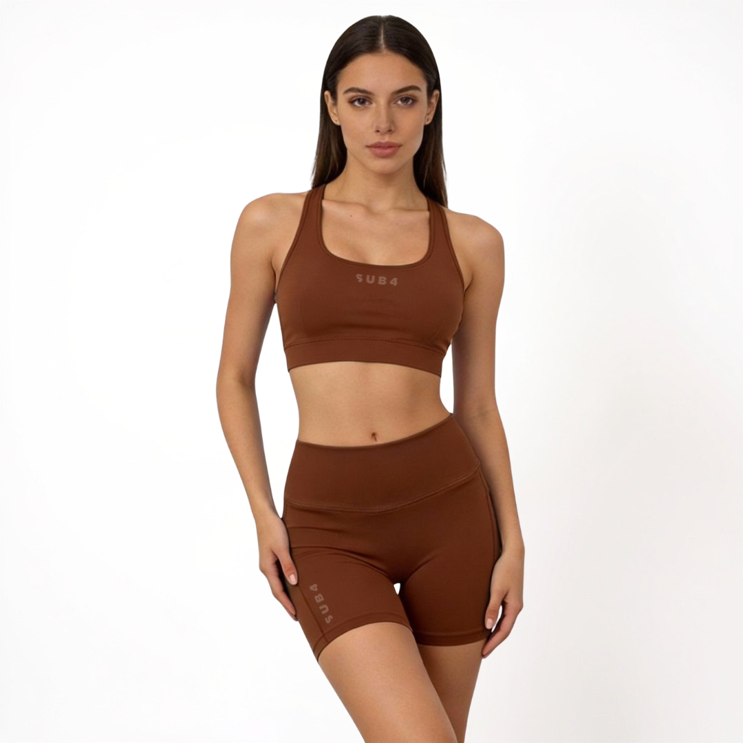Woman wearing a brown sports bra and shorts set on a white background