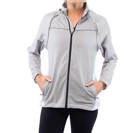 Person wearing a gray zip-up jacket on a white background