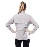 Woman wearing a gray jacket with a visible brand logo on a white background