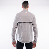 Person wearing a gray jacket with a brand logo on the back against a white background