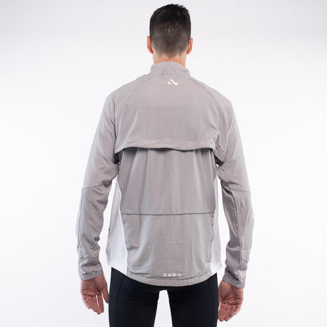 Person wearing a gray jacket with a brand logo on the back against a white background