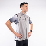 Man wearing a gray vest over a sports shirt on a white background
