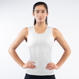 Woman wearing a white tank top against a plain background
