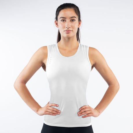 Woman wearing a white tank top against a plain background