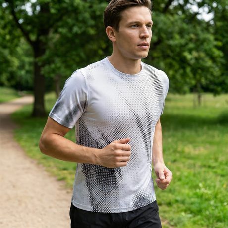 Man running on a path in a park wearing a light grey running t-shirt with black patterns and black running shorts