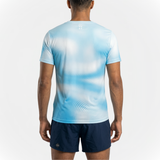 Back view of person wearing a sky blue running t-shirt with patterns and navy running shorts on a white background