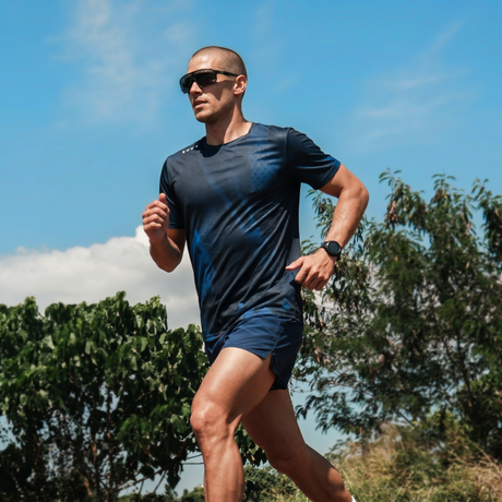 Man running outdoors with trees and blue sky in the background