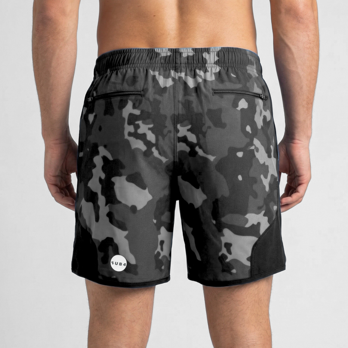 Black camouflage shorts worn by a person on a light gray background