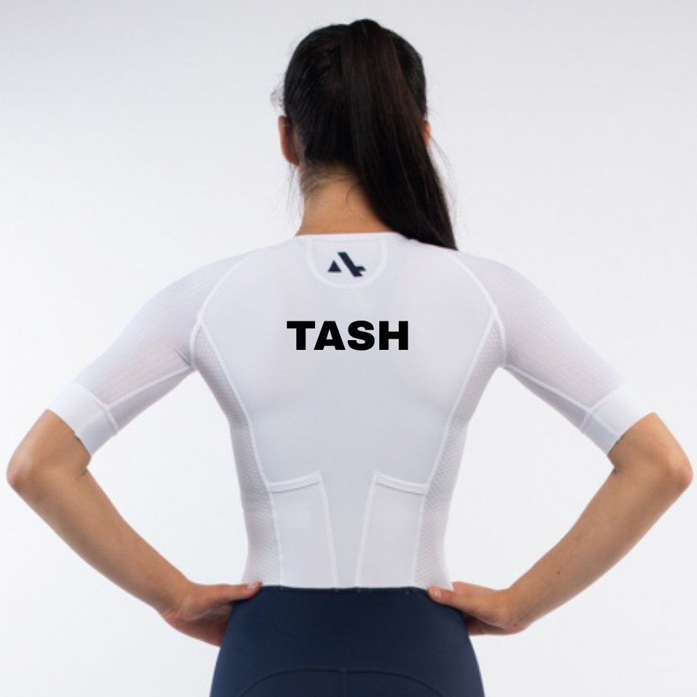Person wearing a white trisuit with 'TASH' personalised name print on a light gray background