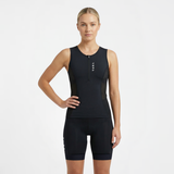 Woman wearing a black sleeveless athletic triathlon top and triathlon shorts on a white background