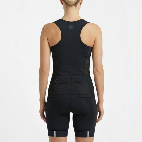 Person wearing a black athletic triathlon top and triathlon shorts on a white background