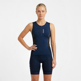 Woman wearing a navy blue athletic triathlon top and triathlon shorts on a white background