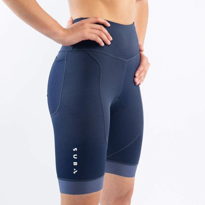 Navy blue athletic triathlon shorts with SUB4 branding worn by a person on a white background