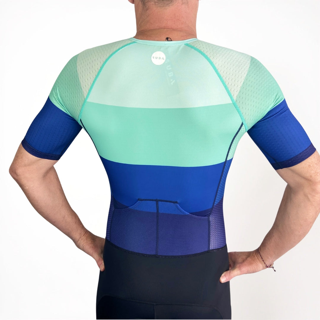 Person wearing a blue and green Triathlon suit on a white background