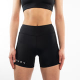 Person wearing black athletic shorts with a brand logo on a white background