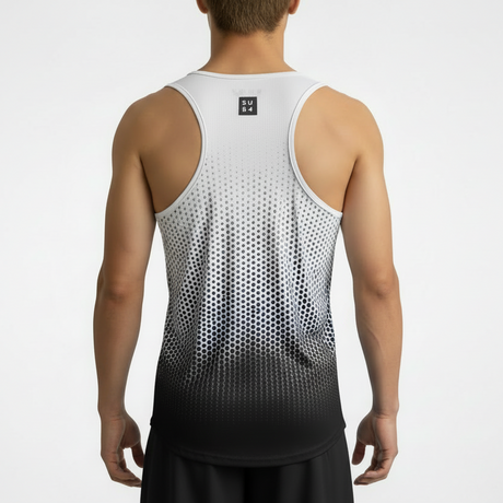 Person wearing a white and black dot geometric gradient tank top on a plain background