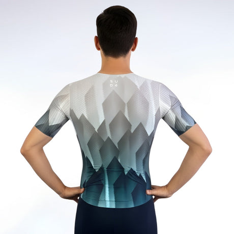 Person wearing a geometric patterned cycling jersey and shorts on a white background