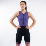 Woman wearing a purple and black triathlon suit on a white background