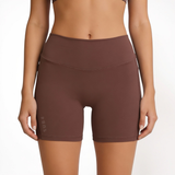 Brown athletic shorts worn by a person on a white background