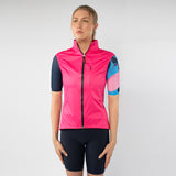 Woman wearing a pink cycling vest and black shorts on a white background