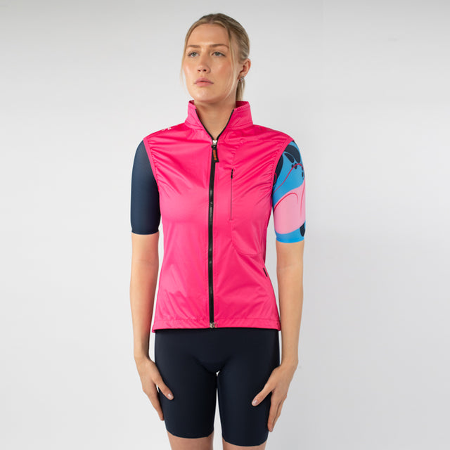 Woman wearing a pink cycling vest and black shorts on a white background