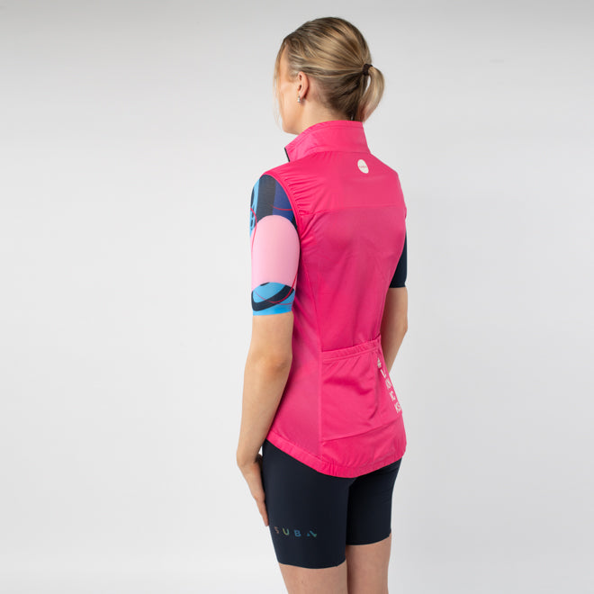 Person wearing a pink cycling vest and black shorts on a light gray background