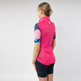 Person wearing a pink cycling vest and black shorts on a light gray background