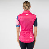 Person wearing a pink vest with a brand logo on a gray background