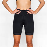 Person wearing black athletic cycling shorts on a plain background