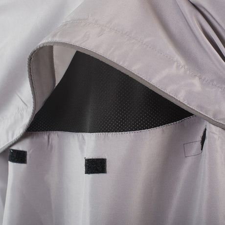 Close-up of a gray raincoat with black interior lining and reflective stripes.